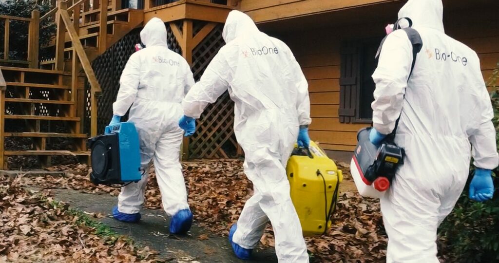 Bio-One technicians arrive onsite wearing personal protective equipment and cleaning equipment. 